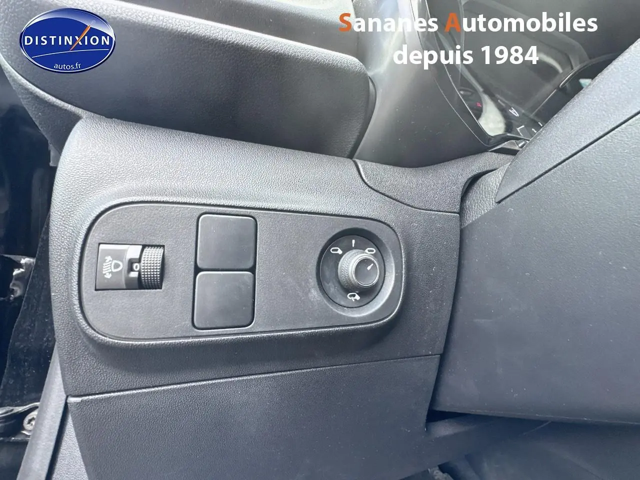 Commande des rétroviseurs et réglage des phares côté gauche dans l'habitacle noir de la Citroën C3 2023.
