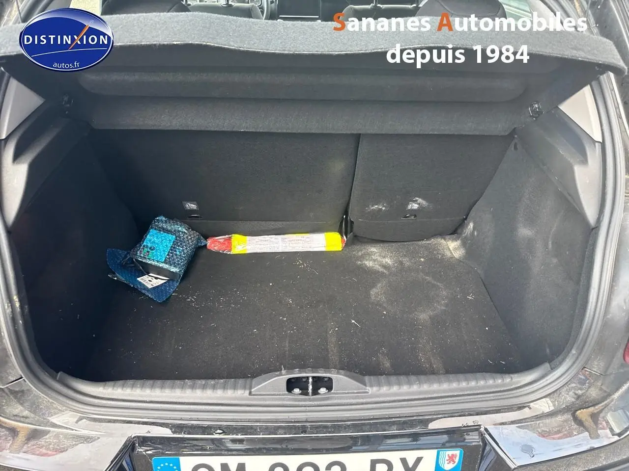 Coffre ouvert d'une Citroën C3 noire 2023, vue arrière montrant l'espace de chargement avec quelques objets à l'intérieur.