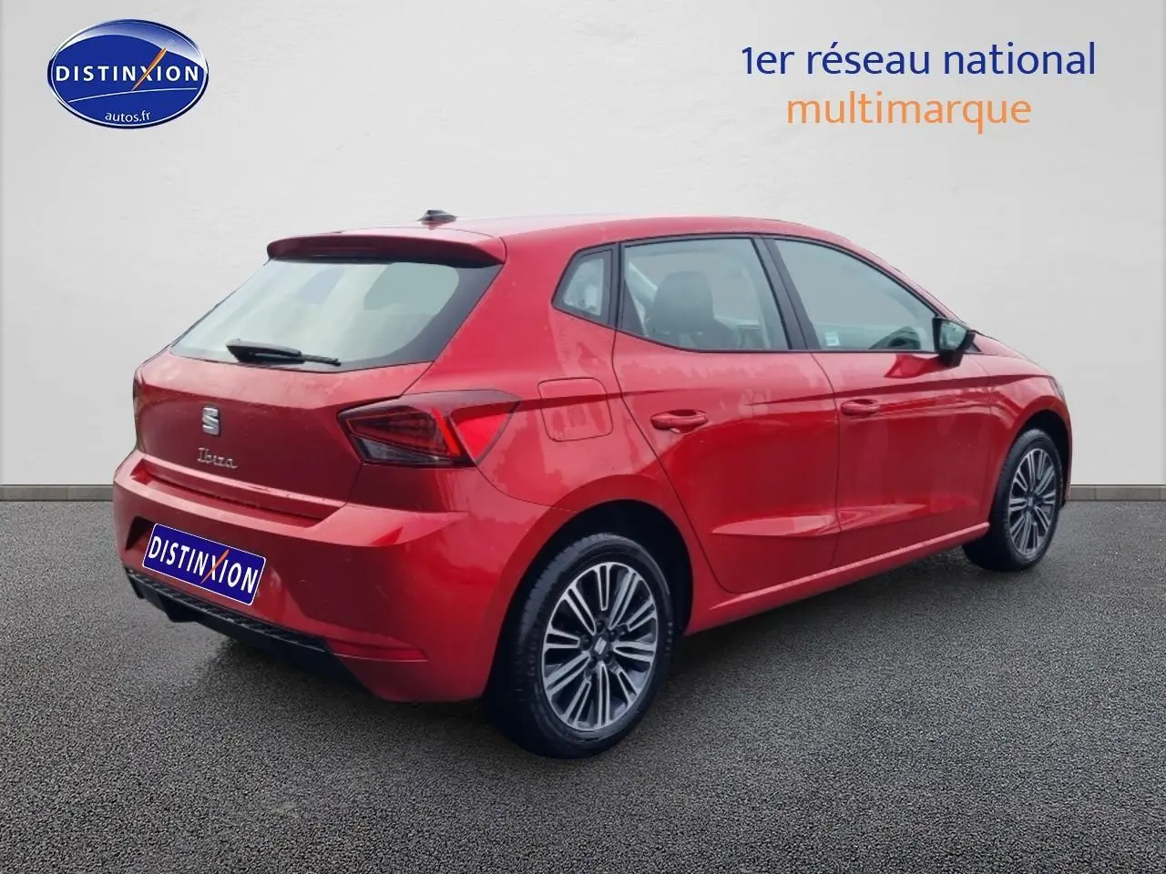 Vue 3/4 arrière droite d'une SEAT Ibiza rouge désir avec jantes alliage et feux arrière LED triangulaires.