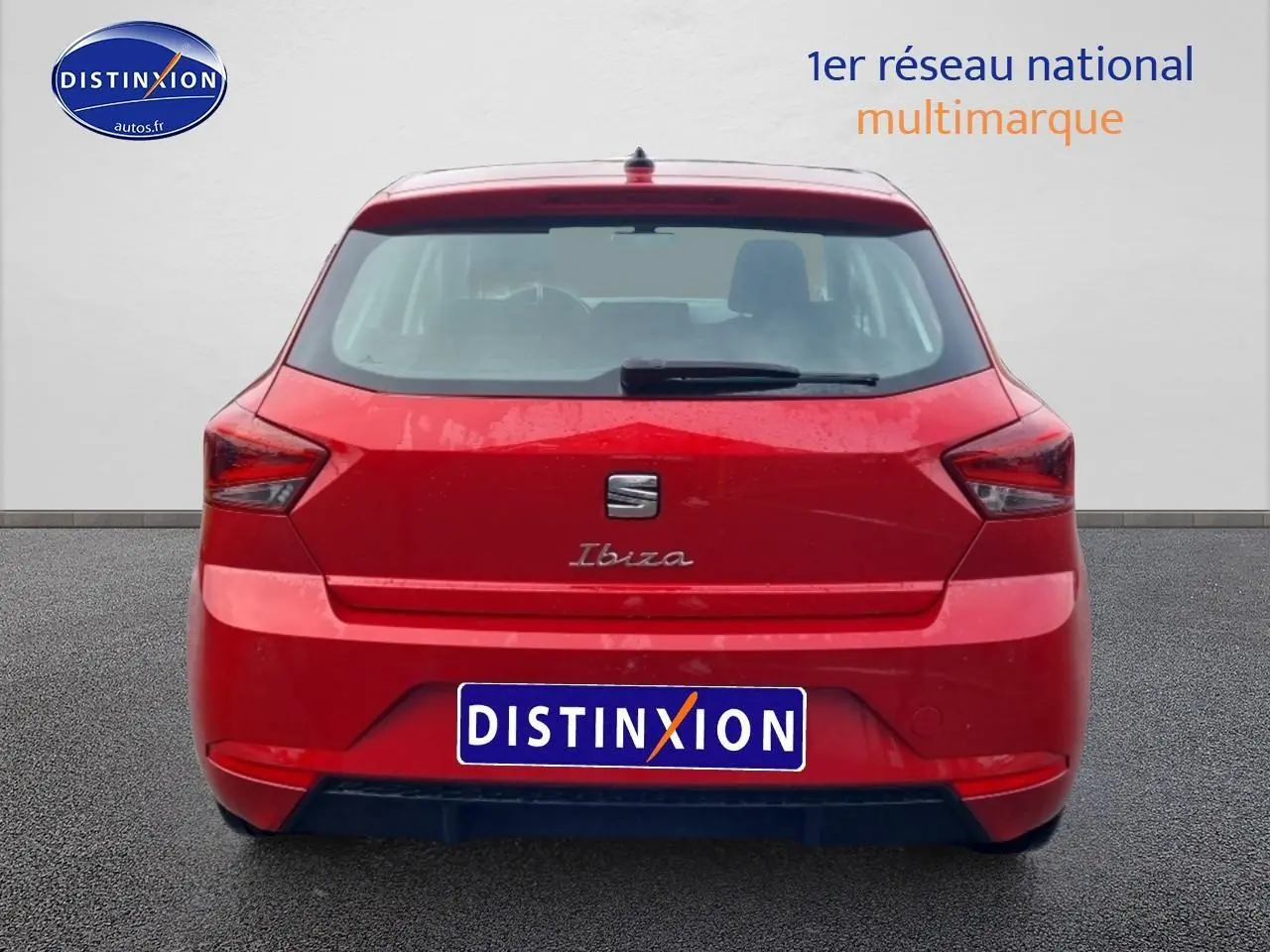 Vue arrière d'une SEAT Ibiza rouge désir 2025 avec feux angulaires et logo centré sur un fond neutre.