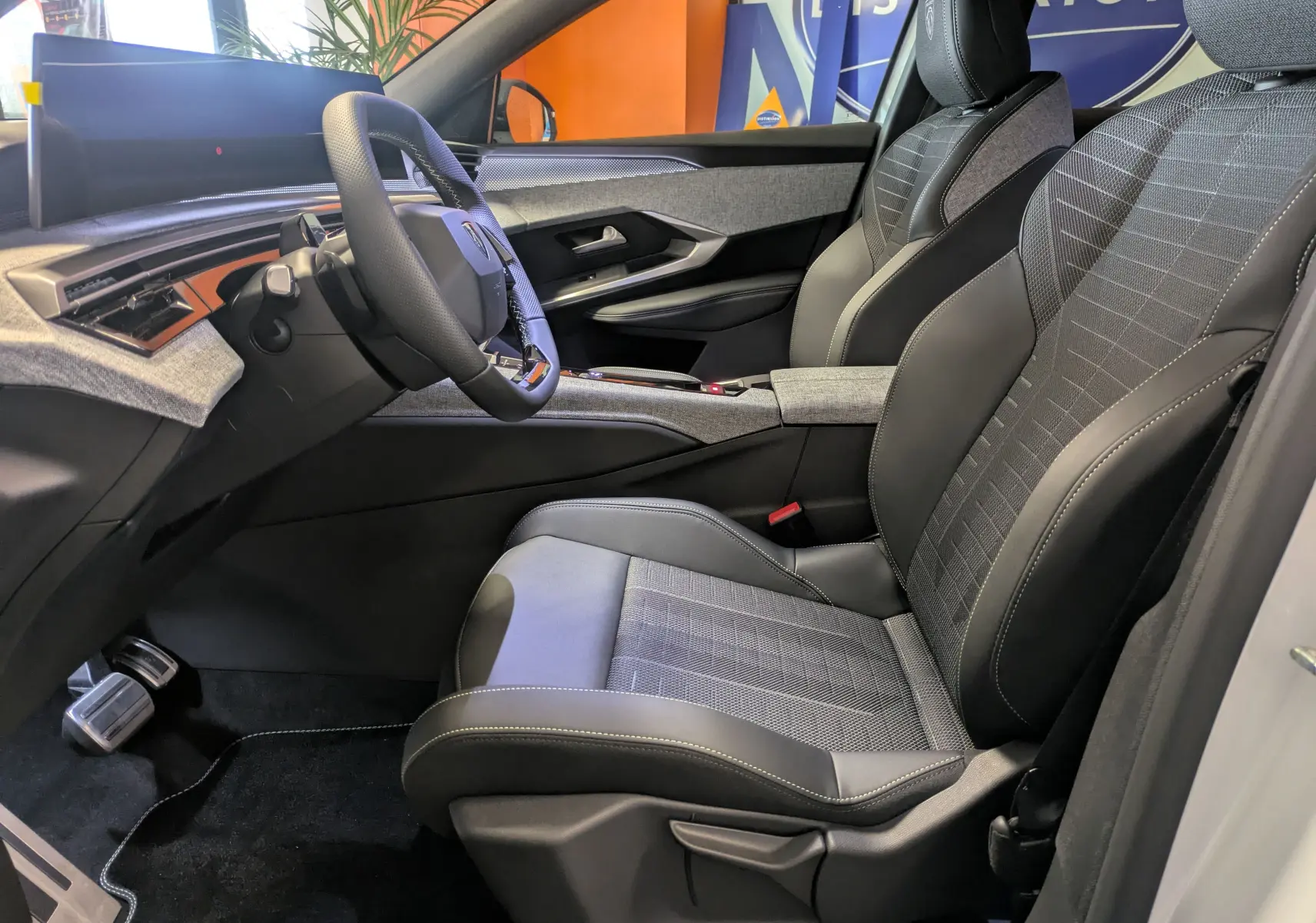 Intérieur avant droit du Peugeot 3008 blanc Okenite, sièges sport en cuir et tissu avec volant compact multifonction.