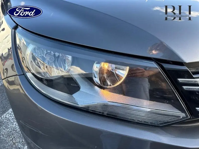 Gros plan sur le phare avant droit gris Crypton du Volkswagen Tiguan 2016 avec calandre partiellement visible.