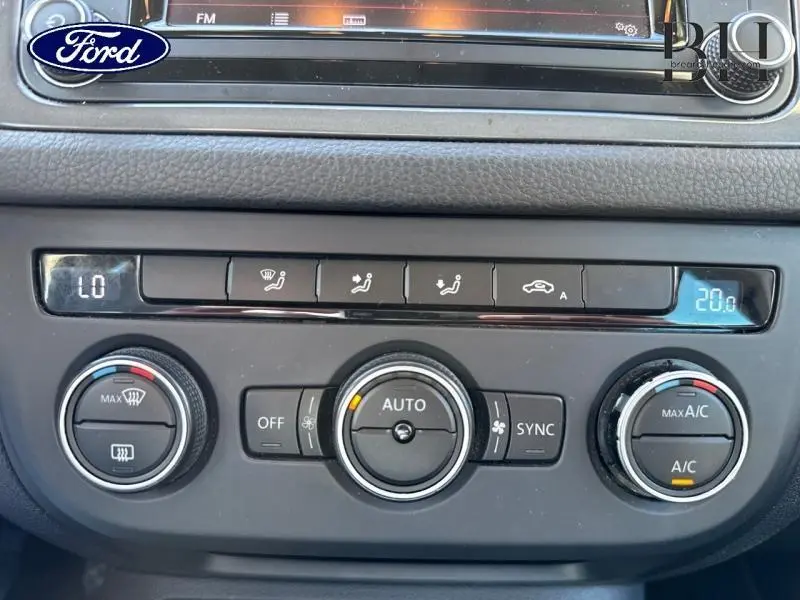 Panneau de commande de climatisation d'une Volkswagen Tiguan gris, vue rapprochée de face avec affichage digital bleu.