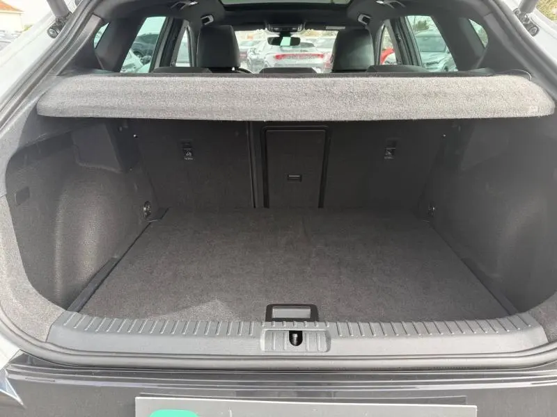 Coffre ouvert vu de l'arrière d'un CUPRA Formentor 1.5 eTSI Hybrid blanc Nevada, montrant l'espace de chargement vide.