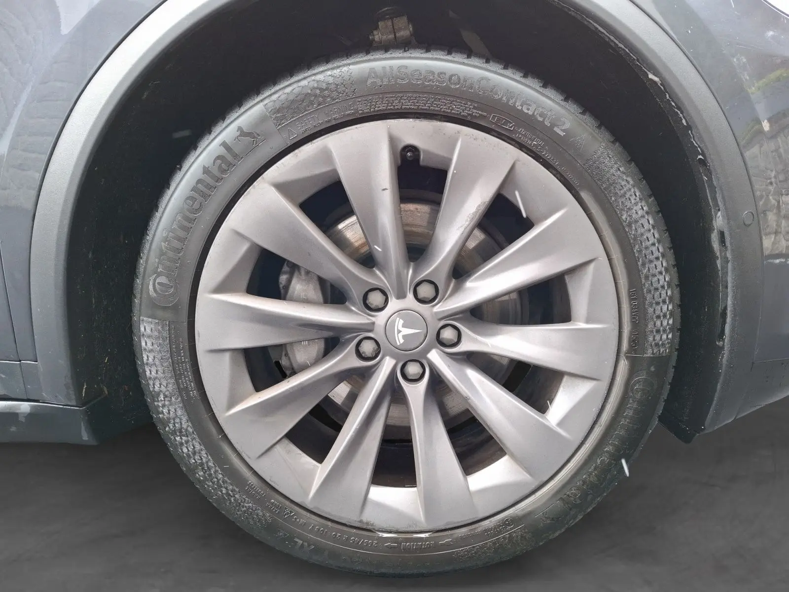 Gros plan sur la jante alliage 20 pouces gris clair du côté avant droit d’un Tesla Model X 100D gris foncé.