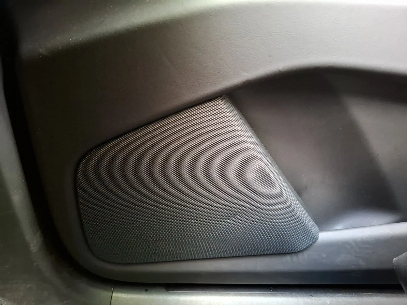 Gros plan sur le haut-parleur intégré à la porte intérieure d’un Tesla Model X 100D gris foncé.