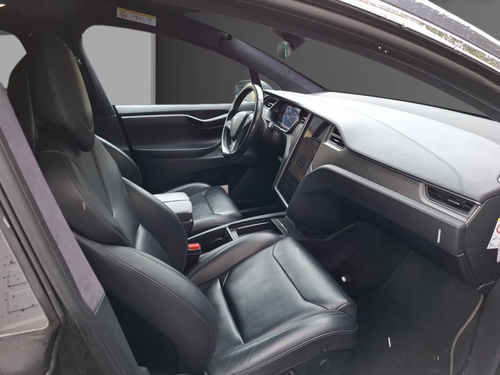 Vue intérieure côté conducteur du Tesla Model X 100D 2018 avec sièges cuir noirs et tableau de bord moderne.