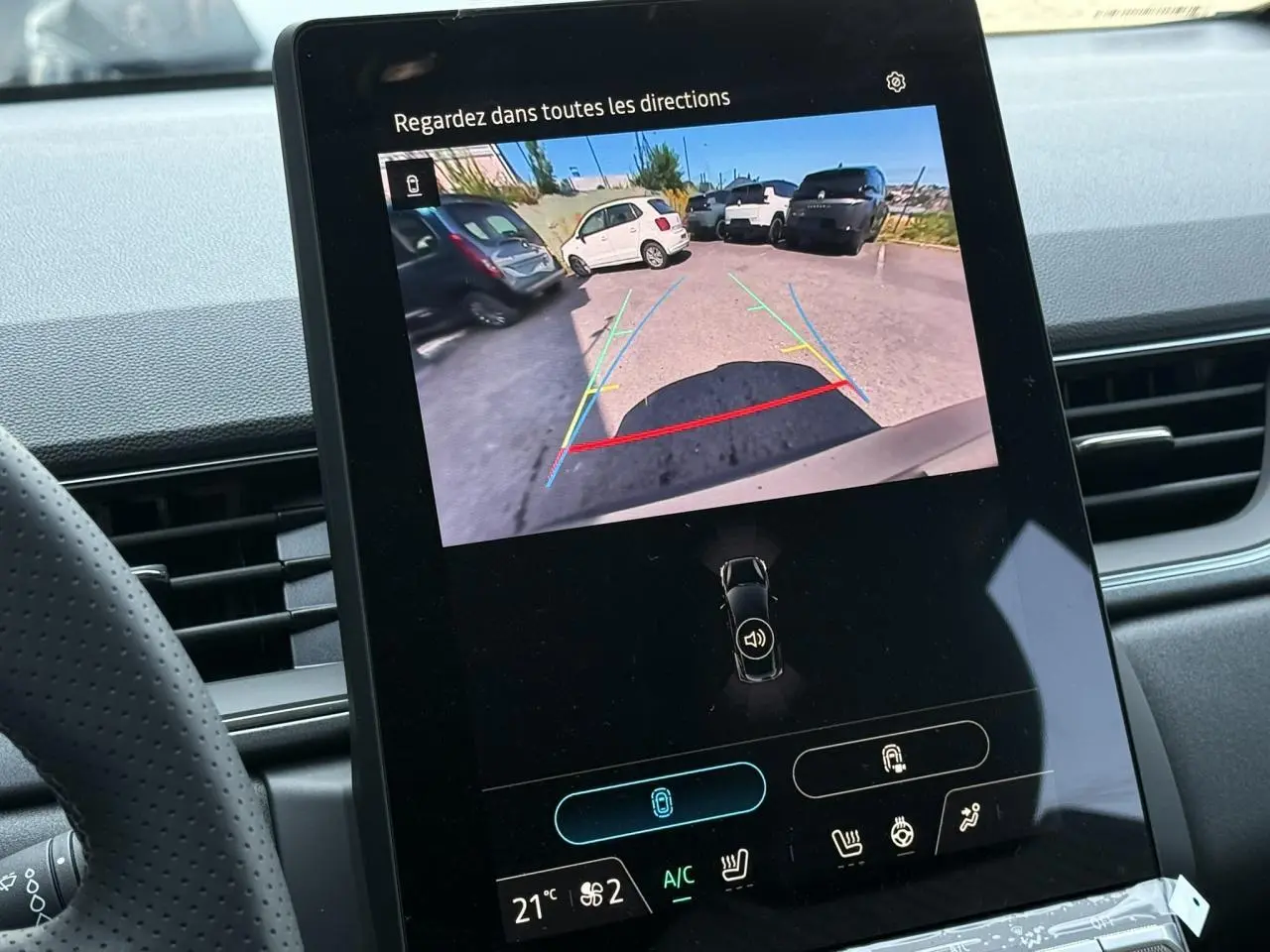 Écran central du Renault Captur gris Cassiopée montrant la caméra de recul avec guidage de trajectoire coloré.