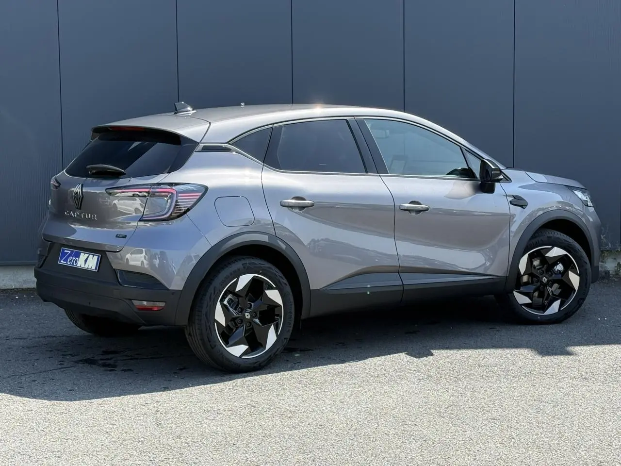 Renault Captur gris Cassiopée vu de profil côté droit, avec jantes 18 pouces bicolores et vitres surteintées.