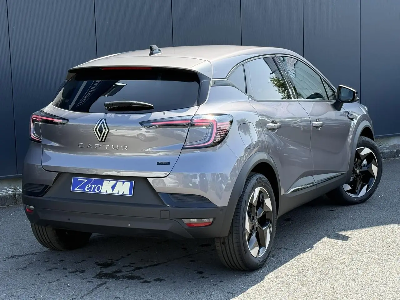 Vue 3/4 arrière droit du Renault Captur gris Cassiopée avec jantes noires et vitres surteintées.