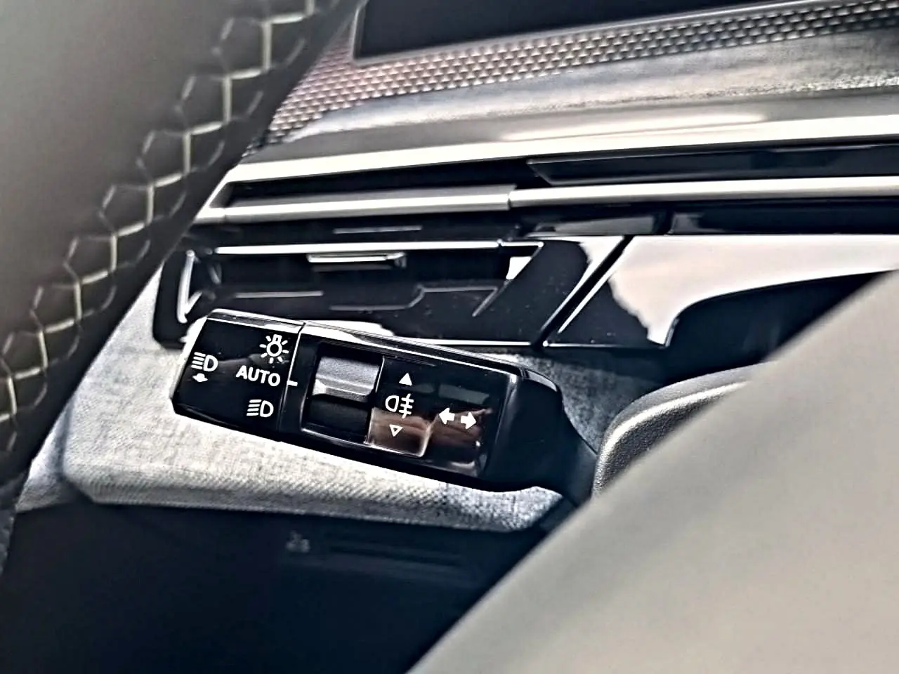 Gros plan sur la commande des phares et clignotants du Peugeot 5008 Hybrid 145 GT e-dcs6, intérieur noir.