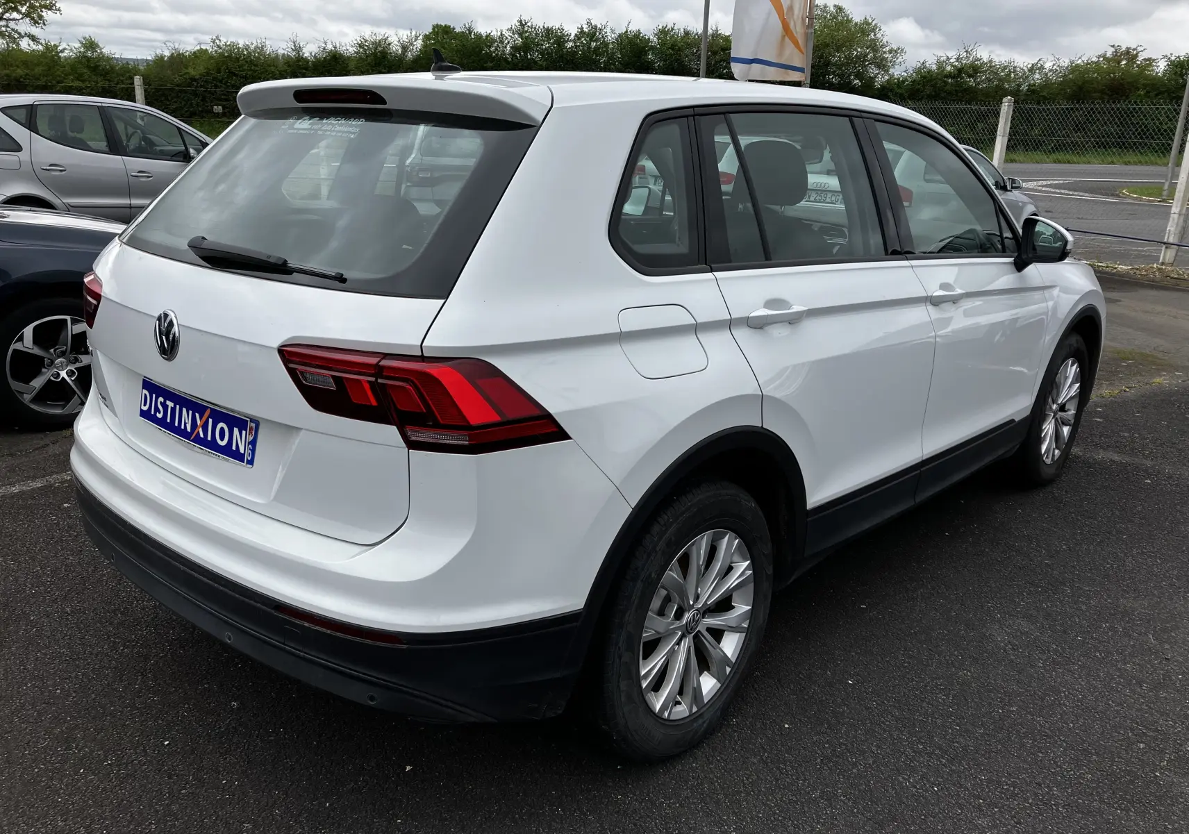Vue 3/4 arrière droite d'un Volkswagen Tiguan blanc 2018 avec feux arrière LED et jantes alliage.