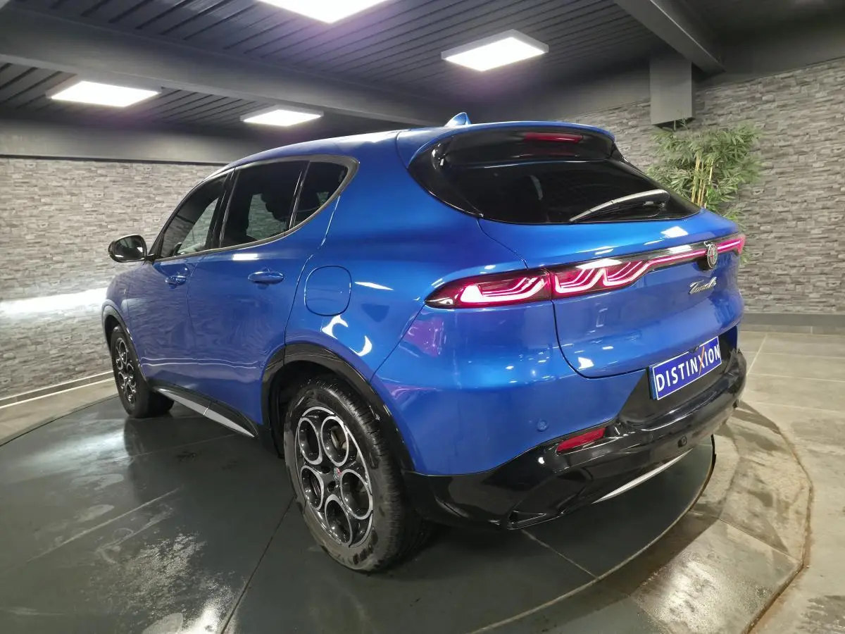 Vue 3/4 arrière droite de l'Alfa Romeo Tonale bleu métallisé avec feux arrière LED et jantes alliage 18 pouces.
