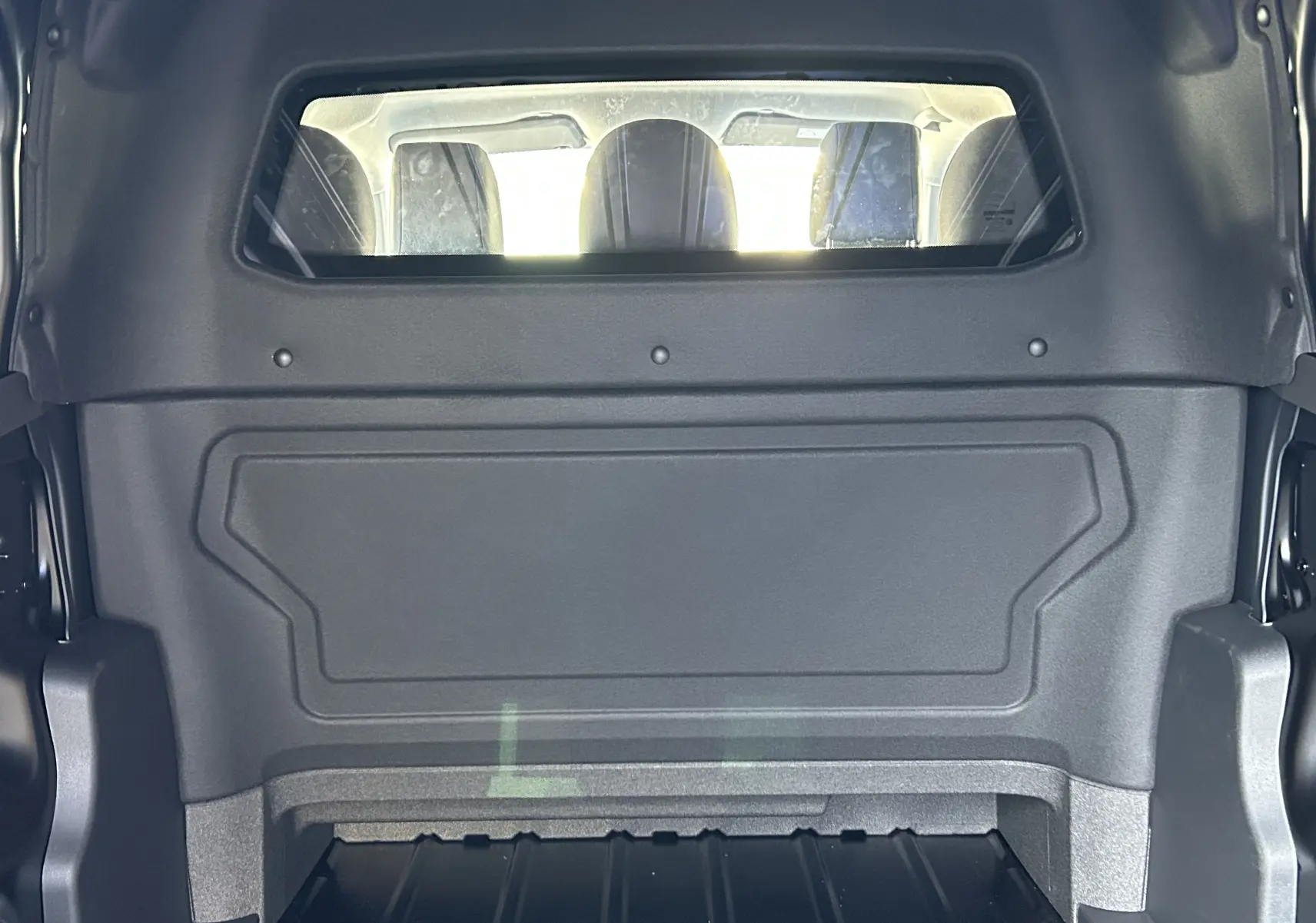 Vue intérieure du coffre du Citroën Jumpy Cabine Approfondie noir, montrant la cloison et les sièges arrière.