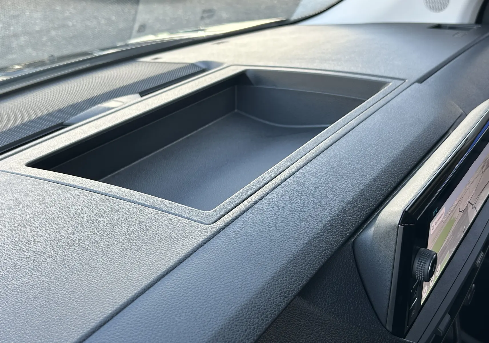 Vue rapprochée du tableau de bord noir du Citroën Jumpy Cabine Approfondie 2025 avec écran tactile et rangement intégré.