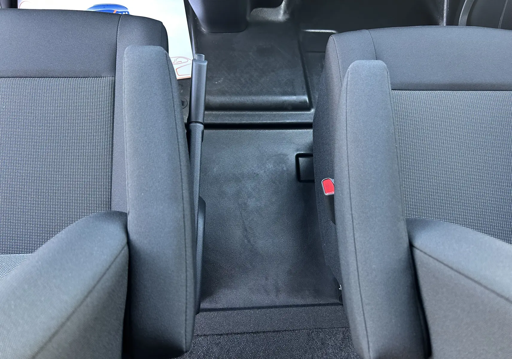 Vue rapprochée de l’intérieur du Citroën Jumpy cabine approfondie 2025, montrant les sièges tissu gris avec accoudoirs et frein à main central.