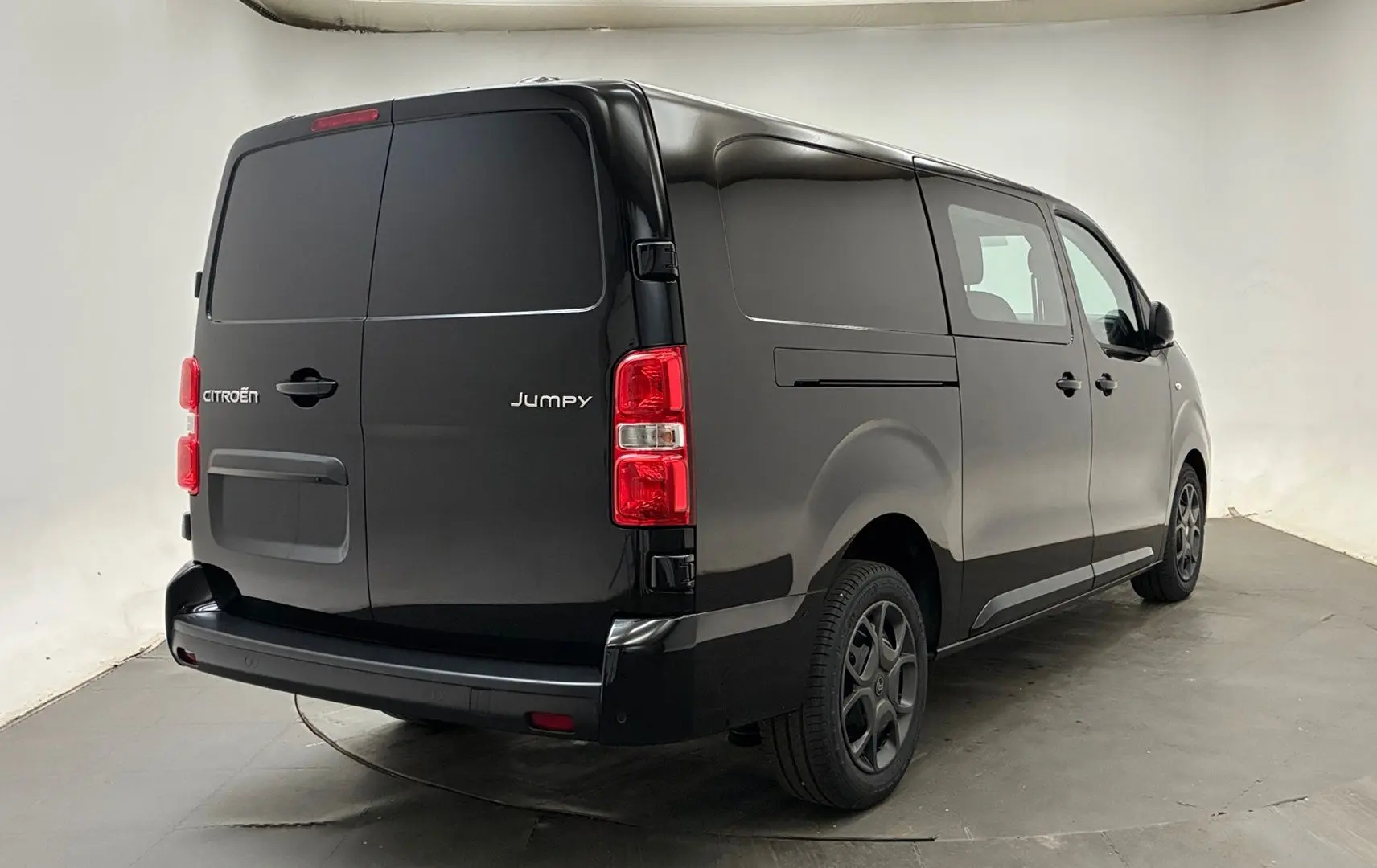 Vue 3/4 arrière droite du Citroën Jumpy Cabine Approfondie noir avec portes latérales et jantes tôles noires.