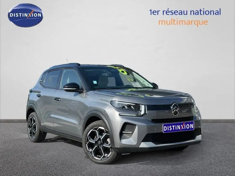 Vue 3/4 avant droite d'une Citroën C3 2025 gris Mercury avec jantes alliage au design hexagonal distinctif.