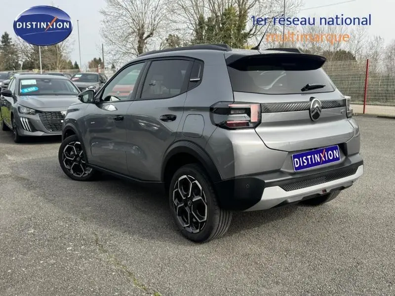 Vue 3/4 arrière droite d'une Citroën C3 2025 gris Mercury avec jantes noires et détails noirs contrastants.