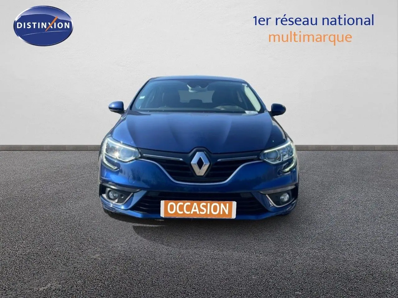Vue frontale d'une Renault Mégane bleu cosmos métal avec phares allumés sur fond neutre.