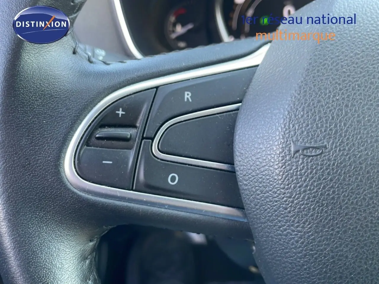 Gros plan sur les commandes du volant noir de la Renault Mégane 2019, mettant en valeur les boutons de régulation.