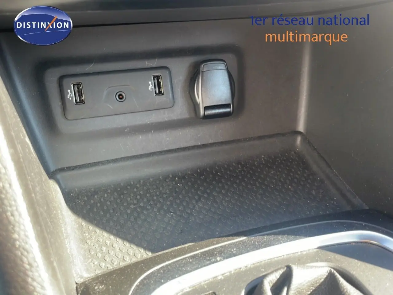 Vue rapprochée de la console centrale avec prises USB et prise 12V sur Renault Mégane bleu cosmos métal.