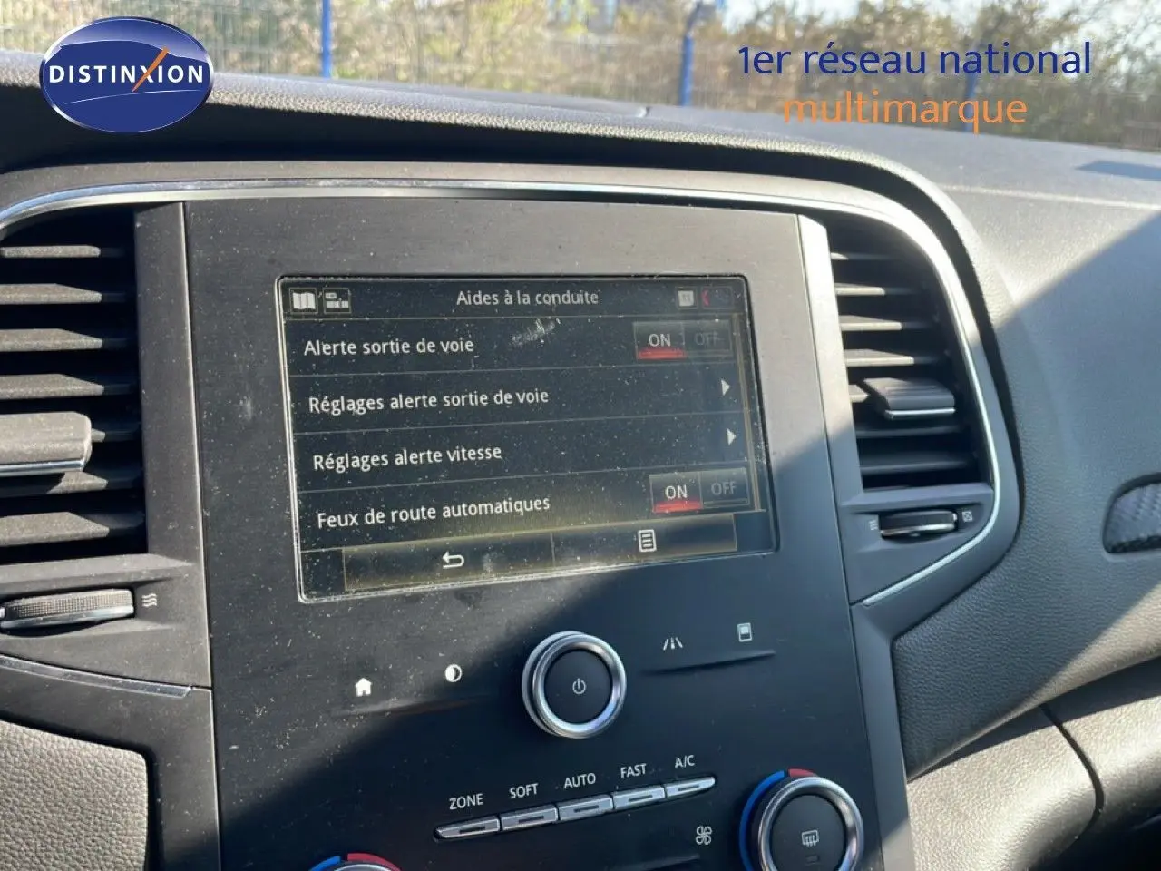 Vue rapprochée de l’écran tactile central du tableau de bord d’une Renault Mégane 2019, affichant les aides à la conduite.