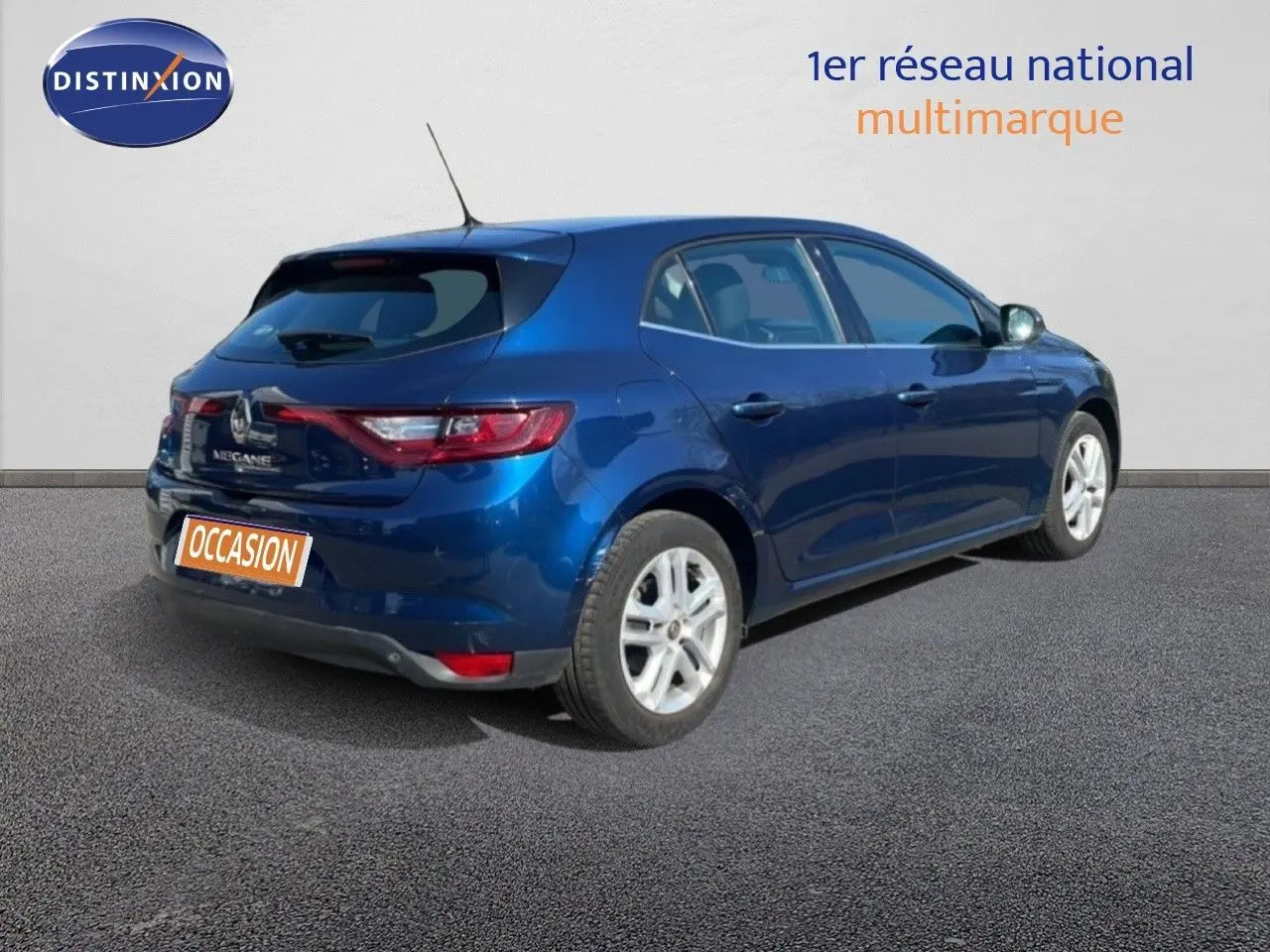 Vue 3/4 arrière droite d'une Renault Mégane bleu cosmos métal, avec feux arrière allongés et jantes argentées.