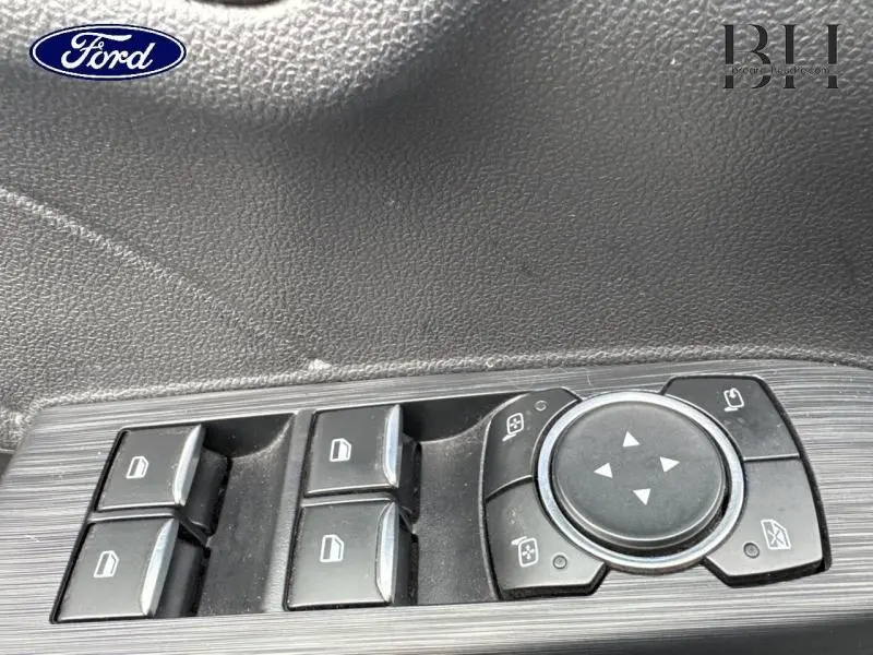 Gros plan sur les commandes des vitres et rétroviseurs côté conducteur du Ford Kuga 2023, finition Vignale.