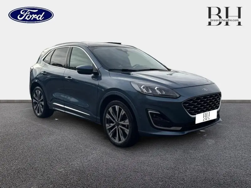 Ford Kuga bleu azur métallisé en vue 3/4 avant droit avec jantes alliage 20 pouces et toit ouvrant panoramique.