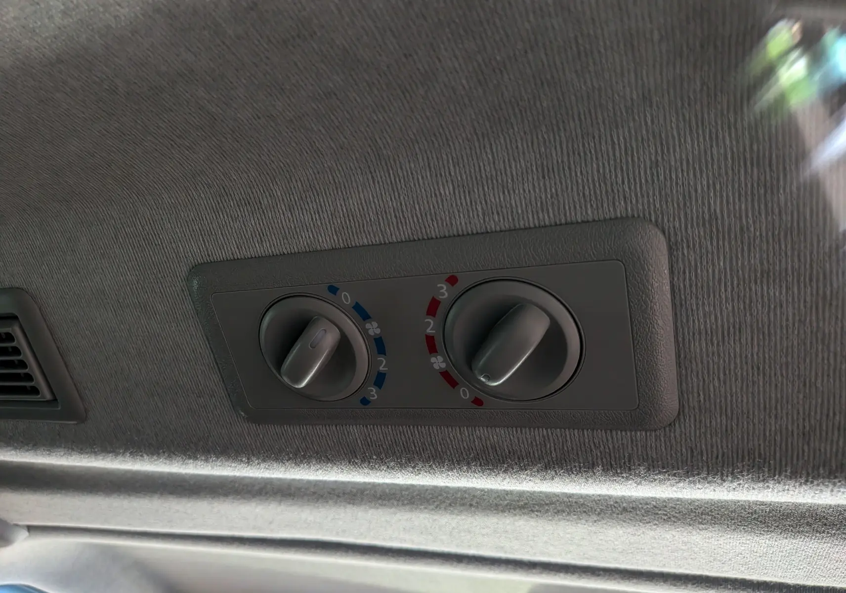 Détail des commandes de climatisation arrière sur le plafond intérieur gris du Nissan Primastar Combi L2H1 2026.