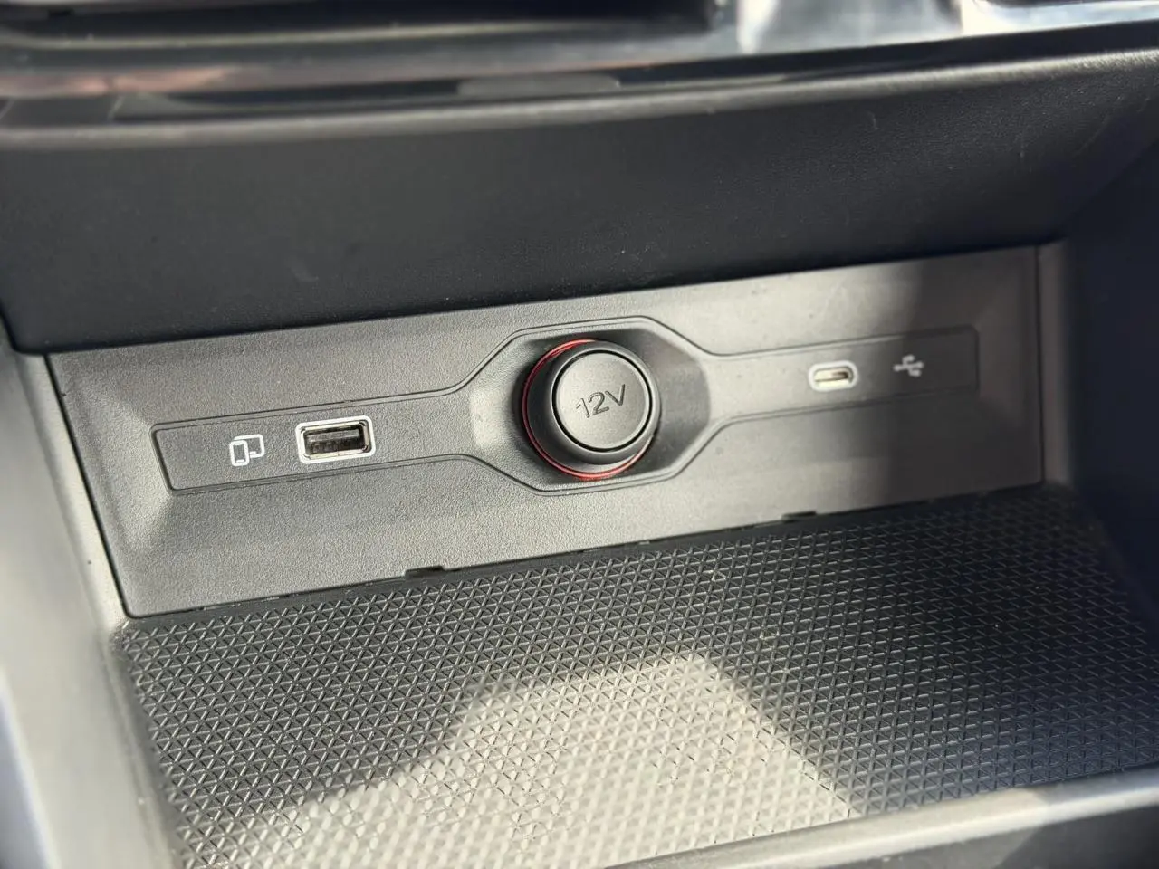 Gros plan sur la prise 12V et ports USB intégrés dans la console centrale noire du MG3 2024.