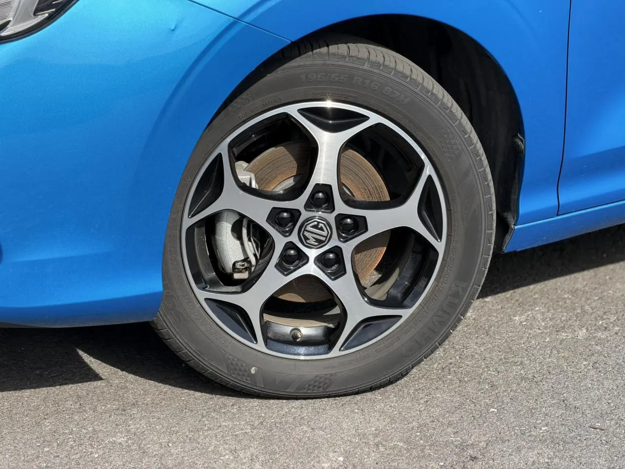 Gros plan sur la roue avant gauche de la MG3 1.5 Hybrid+ 195 Comfort bleu Como avec jante alliage 16 pouces.