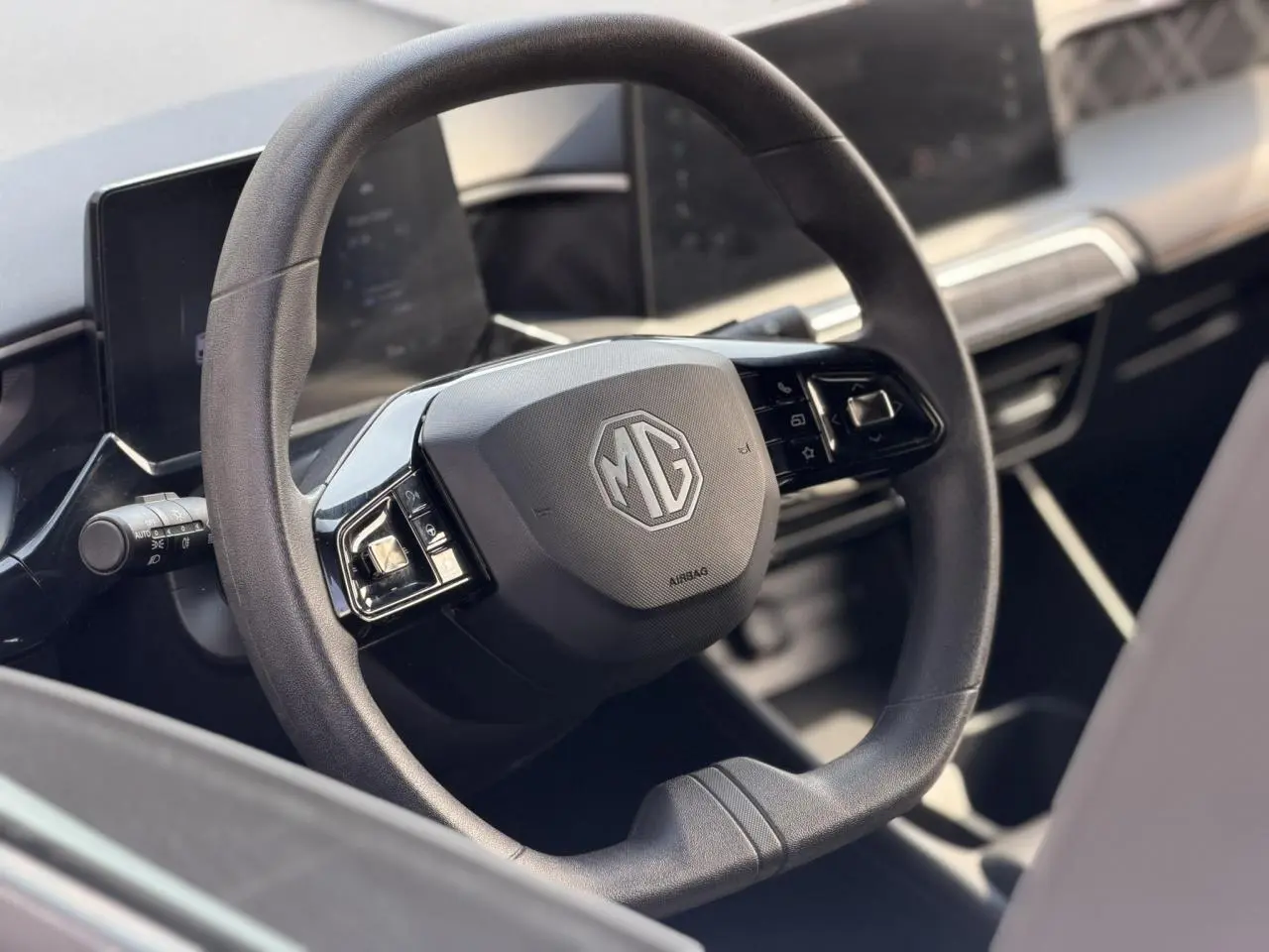 Vue rapprochée du volant multifonction noir avec logo MG au centre dans l’habitacle du MG3 2024.
