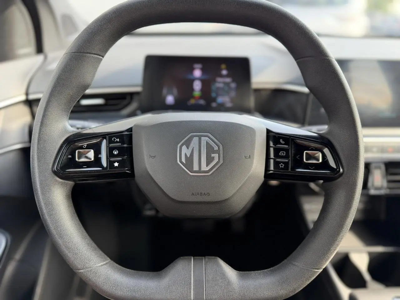 Gros plan sur le volant noir du MG3 1.5 Hybrid+ 195 Comfort 2024 avec logo MG et commandes intégrées.