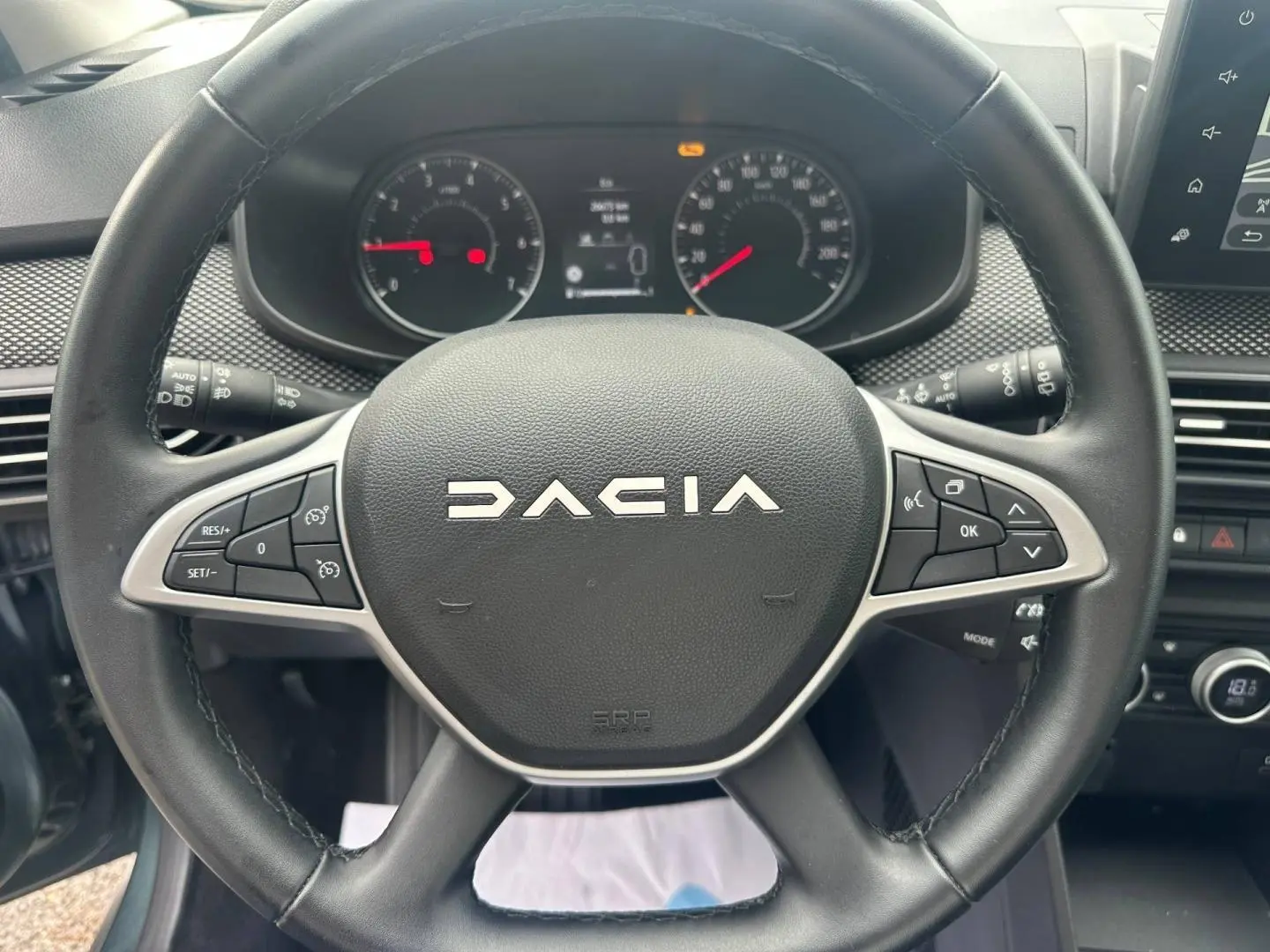 Vue rapprochée du volant noir de la Dacia Jogger 2025 avec commandes intégrées et tableau de bord visible.