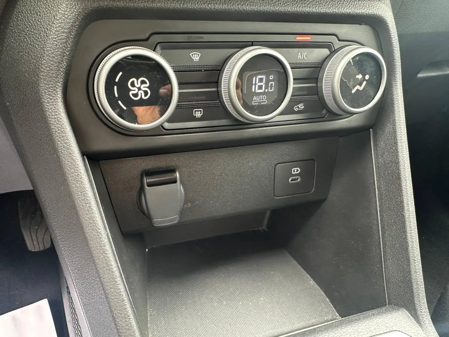 Gros plan sur la console centrale du DACIA JOGGER 2025 montrant les commandes de climatisation digitales et prises USB.