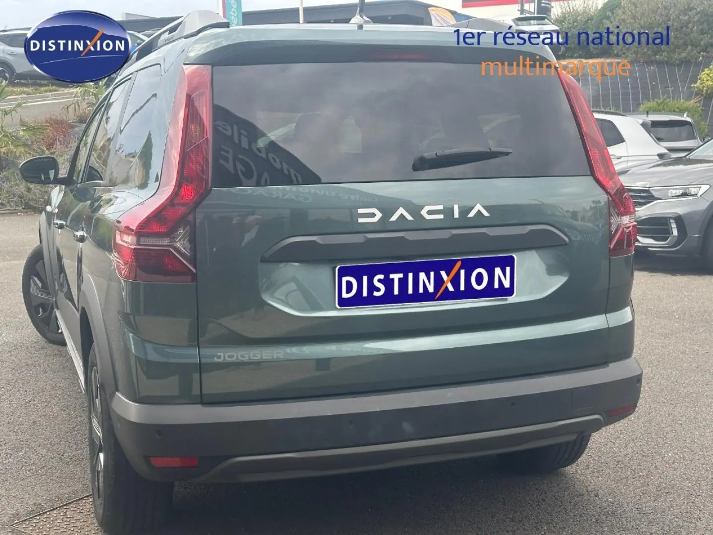 Vue arrière d'un Dacia Jogger 2025 vert cèdre métallisé avec feux arrière verticaux et lunette arrière surteintée.