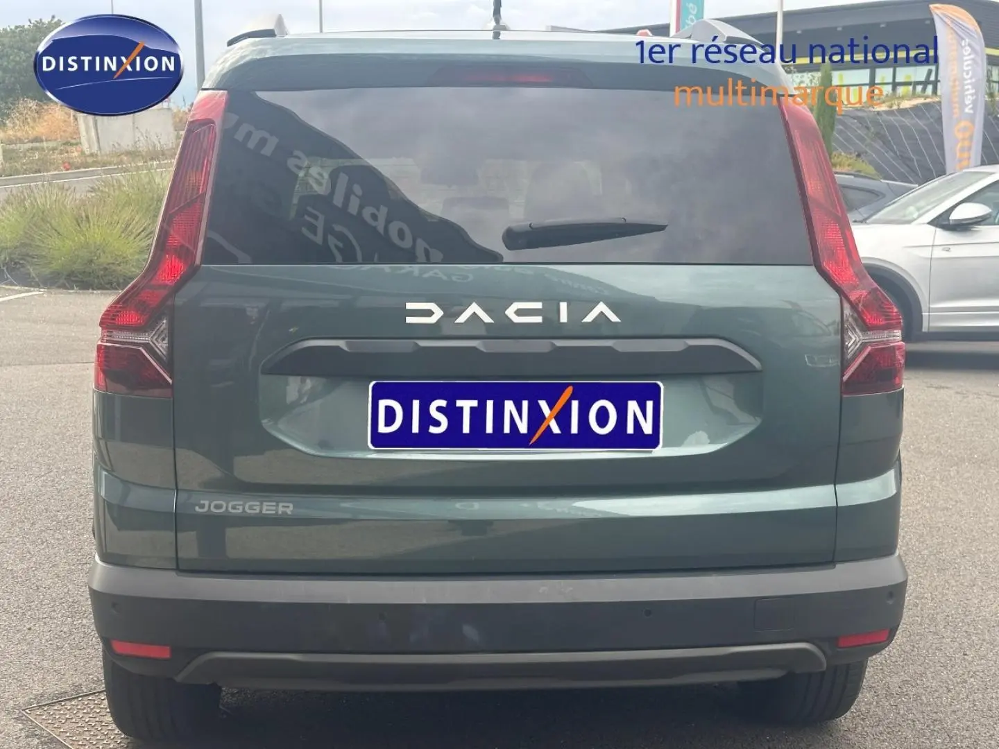 Vue arrière d'un Dacia Jogger 2025 vert cèdre métallisé avec feux verticaux et lunette arrière surteintée.