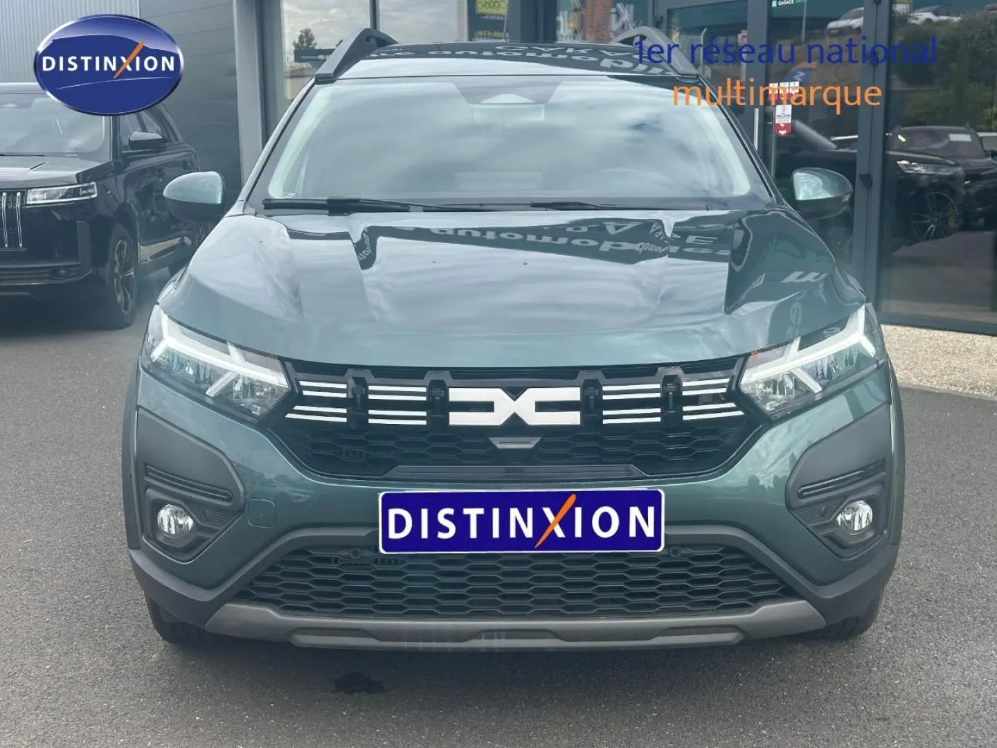 Vue frontale du Dacia Jogger 2025 en Vert Cèdre métallisé avec calandre noire et phares LED allumés.