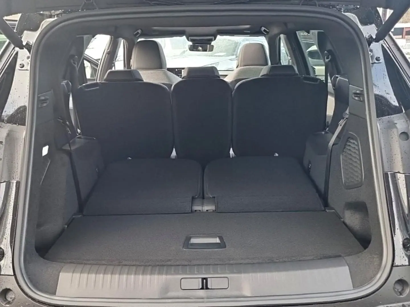 Coffre ouvert d’un Peugeot 5008 noir, vue arrière montrant les sièges arrière rabattus et l’espace de chargement.