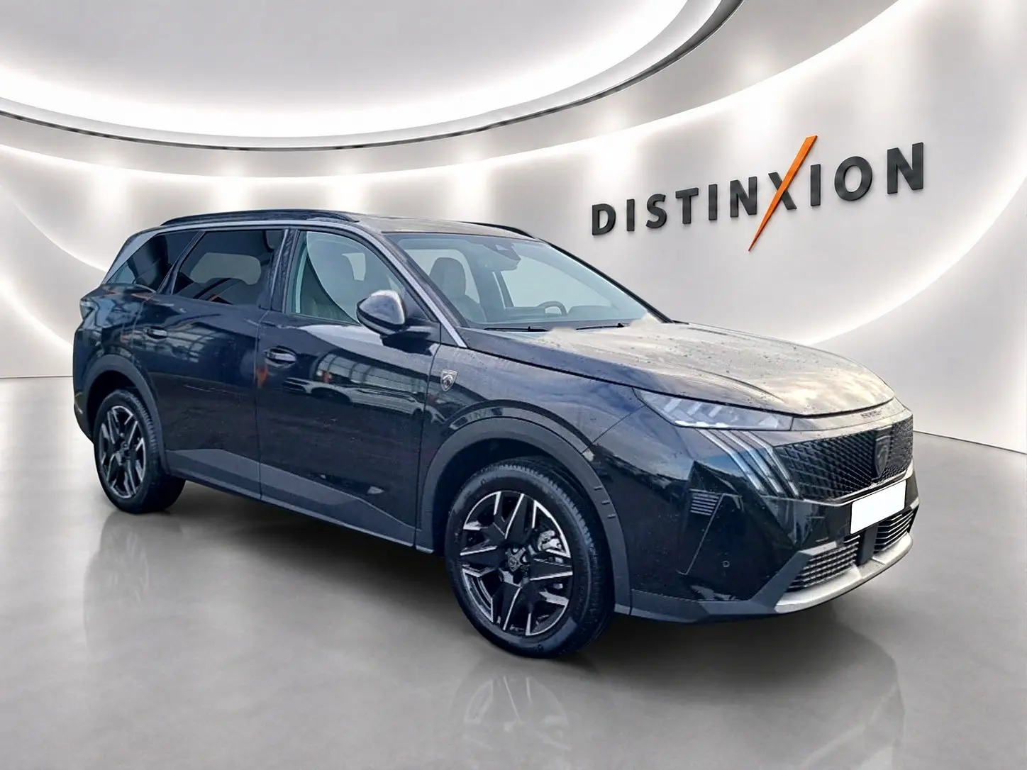 Peugeot 5008 Hybrid 145 GT noir en 3/4 avant droit, avec jantes alu et calandre distinctive dans un showroom.