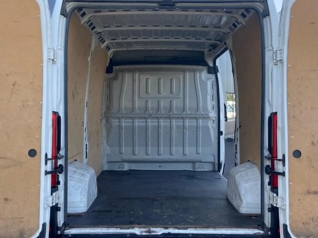 Vue arrière ouverte du Peugeot Boxer Fourgon blanc 2019, montrant l'intérieur utilitaire avec plancher bois et parois tôlées.