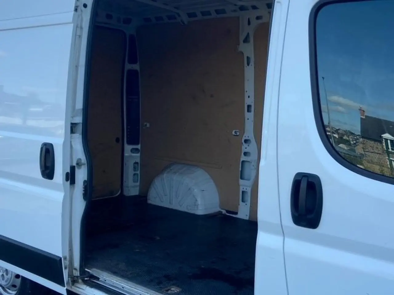 Vue latérale droite du Peugeot Boxer Fourgon blanc 2019 avec porte coulissante ouverte montrant l'intérieur vide et plancher bois.