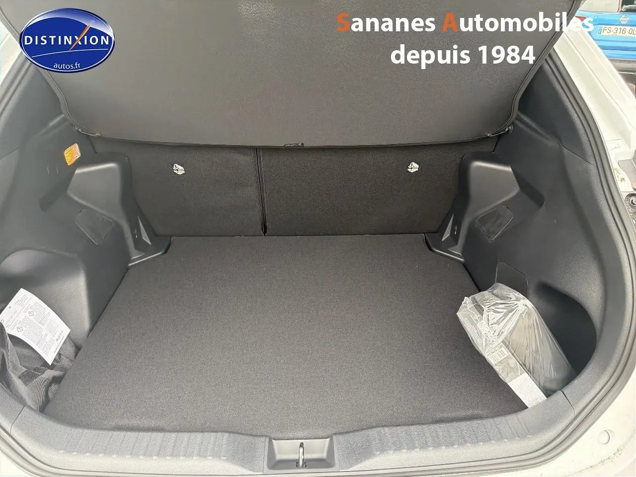 Coffre ouvert vu de l'arrière d'une Toyota Yaris Cross blanche, montrant un espace de chargement propre et spacieux.