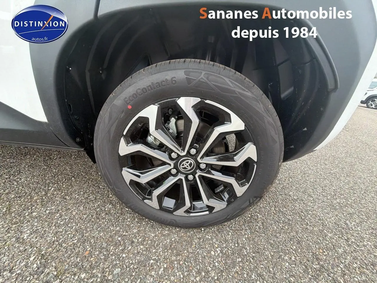 Gros plan sur la jante alliage noire et argentée côté arrière droit de la Toyota Yaris Cross blanche 2025.