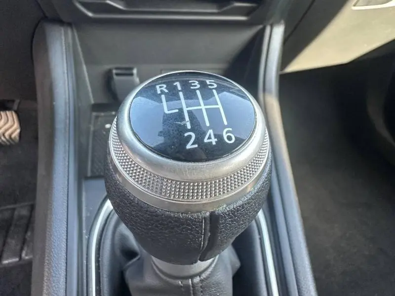 Gros plan sur le levier de vitesses manuel noir du Renault Captur 2025, avec marquage blanc des six rapports et marche arrière.