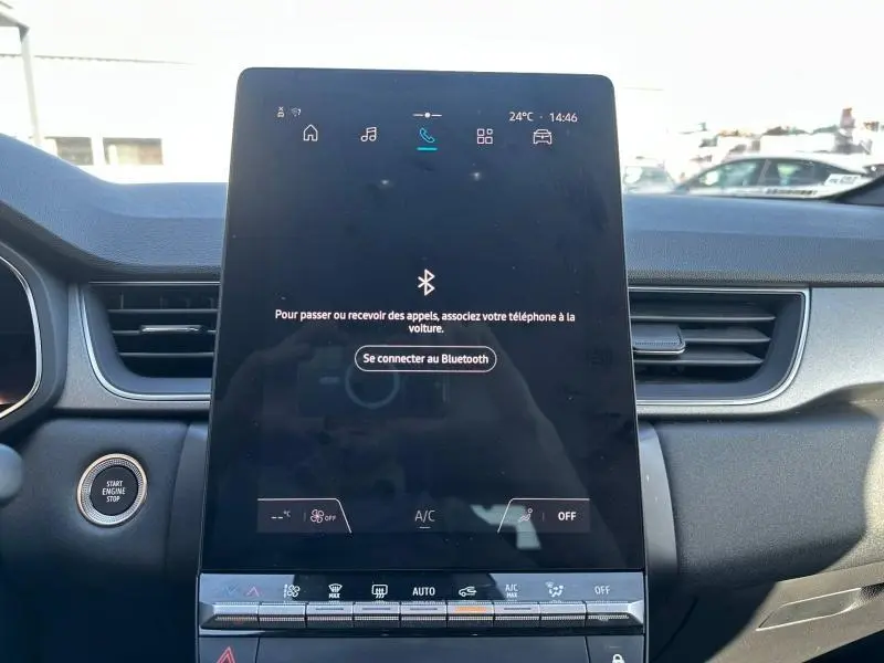 Vue rapprochée de l’écran tactile central du tableau de bord du Renault Captur 2025, intérieur noir avec bouton Start Engine Stop visible.