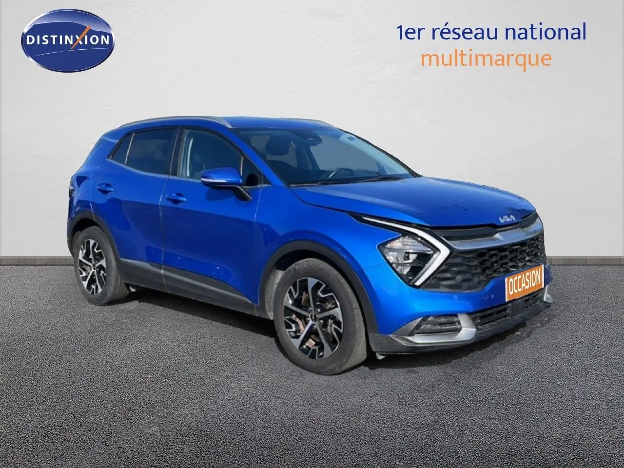 KIA Sportage bleu fusion métal en 3/4 avant droit, mettant en valeur sa calandre distinctive et ses jantes stylées.