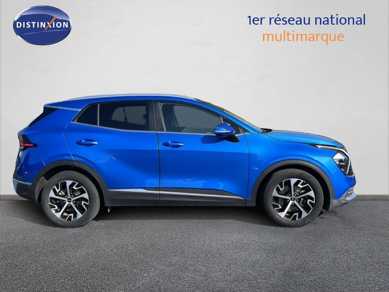 Vue latérale côté gauche d'un KIA Sportage bleu fusion métal 2022 avec jantes alliage et lignes dynamiques.